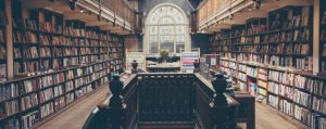 Library aisle with wooden shelves and hundreds of books