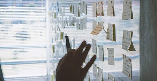 Man placing post-it notes on wall